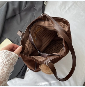 Détail du sac cabas en daim marron avec doublure rayée et poche zippée sécurisée