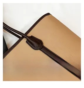 Macro shot of khaki lychee grain leather tote bag with dark brown trim and reinforced stitching
