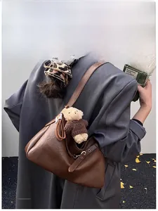 Vue détaillée de l'arrière d'un grand sac fourre-tout marron avec ours en peluche