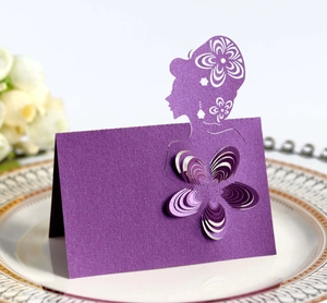 Detail of laser-cut place card in deep purple pearlescent paper with floral girl silhouette