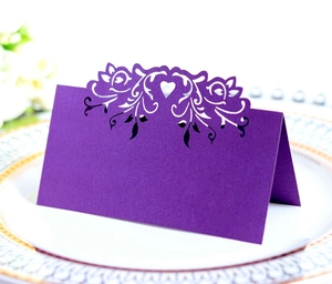 Detailed laser-cut purple heart table card placed on an elegant white china plate