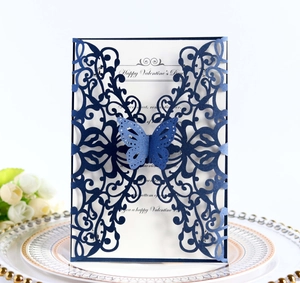 Laser cut butterfly wedding invitation card in navy blue on an elegant dinner plate