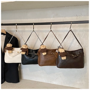 Détail de sacs fourre-tout en similicuir colorés avec breloques d'ours en peluche
