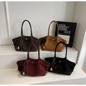 Selection of suede tote bags in dark brown, yellow, burgundy, and black with fuzzy charms