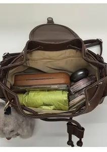 Top view of spacious brown leather bucket bag interior with items and zipper pocket
