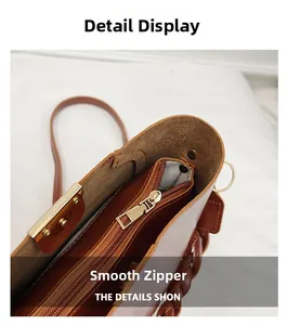Close-up of smooth zipper with gold puller and herringbone lining on brown leather bag