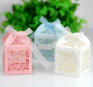 Detailed laser-cut gift boxes in pink, light blue, and beige with elegant organza ribbons