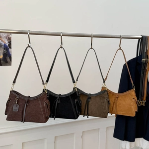 Detail view of retro suede shoulder bags in dark coffee, black, grey and yellow shades