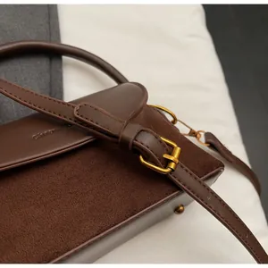Detail of soft leather shoulder bag with adjustable strap and textured suede contrast