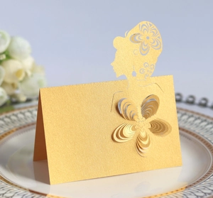 Detail of laser-cut gold table card with intricate floral design and 3D flower accent
