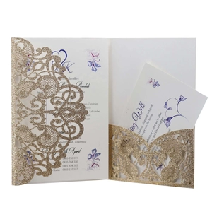 Detail of laser cut gold glitter invitation cover with purple floral inner card
