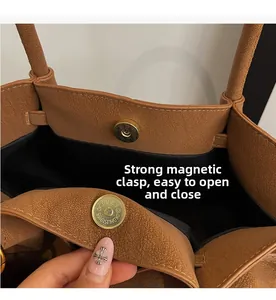 Detailed macro view of the strong magnetic buckle closure on a brown lychee pattern handbag