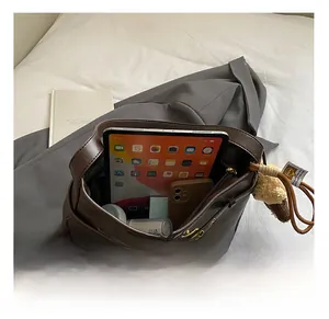 Vue intérieure d'un grand sac cabas marron foncé montrant un espace pour tablette et accessoires