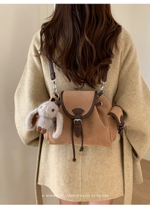 Brown vintage suede backpack with rabbit charm shown from a back-view model shot