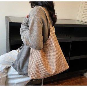 Detail of large woven tote bag featuring brown and beige textured pattern and hobo style