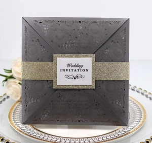 Detailed laser-cut floral wedding invitation with a glittery gold belly band and card