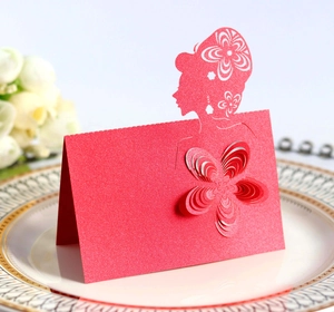 Macro detail of laser-cut red wedding place card with a floral 3D cutout design