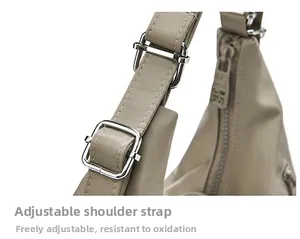 Detail of adjustable shoulder strap with silver metal buckle on beige tote bag