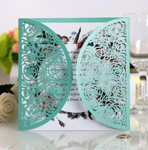Close-up of laser-cut mint green glitter wedding invitation with floral rose detail