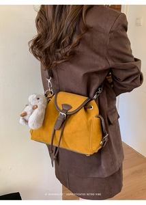 Detail view of ginger suede retro crossbody bag with plush rabbit charm and flap closure