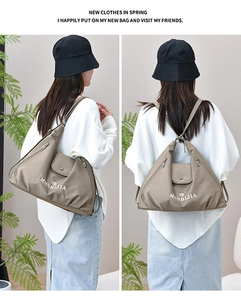 Detail view of the khaki nylon tote bag showing fold design and versatile shoulder straps