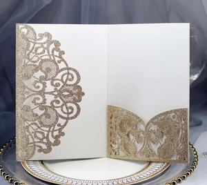 Detailed view of laser-cut wedding invitation cover with gold glitter texture