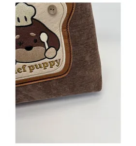 Close-up of chef puppy embroidery on brown canvas backpack with detailed stitching