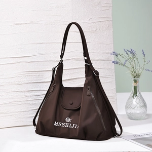 Close-up of brown large capacity tote bag with white logo and side zipper details