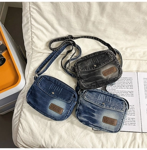 Détail de sacs bandoulière en denim vintage bleu et gris avec étiquettes de marque en cuir