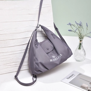 Detail of dark grey-purple versatile nylon tote bag featuring front magnetic flap pocket