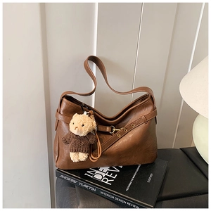 Détail d'un sac cabas en similicuir marron avec un joli pendentif en peluche d'ours