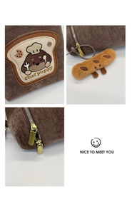 Detail of corduroy bag with puppy embroidery, golden zippers and baguette charm
