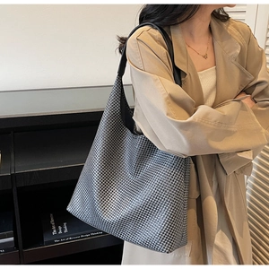 Detailed view of woven patterned tote bag featuring black and white houndstooth fabric