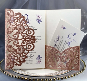 Detail view of laser cut rose gold glitter wedding invitation with inner cards on tray