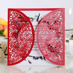 Macro detail of red laser-cut rose invitation with pearlescent finish and white inner card