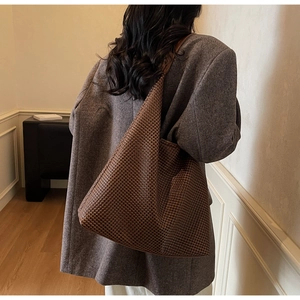 Detail of dark brown woven tote bag showing large capacity and rich texture