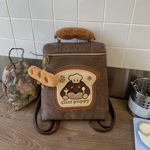 Detail of chef puppy embroidery and baguette plush handle on corduroy backpack