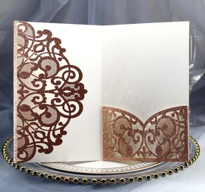 Macro detail of rose gold laser-cut invitation with glitter texture and inner card pocket