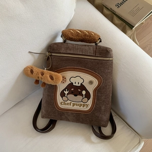 Detail of brown corduroy backpack with puppy embroidery and bread plush handle charm