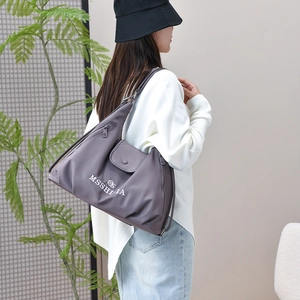 Model wearing a deep purple nylon tote bag with MSSHIA logo and zipper detail