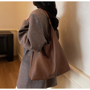 Brown woven leather tote bag shown on a model's shoulder for stylish commute use