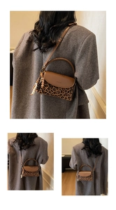 Close-up of leopard print crossbody bag with brown leather flap and beaded tassel detail