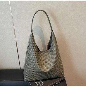 Macro view of olive green woven texture and premium leather strap on the tote bag