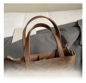Detail of brown lychee grain leather tote bag with silver metal hooks and sturdy handles
