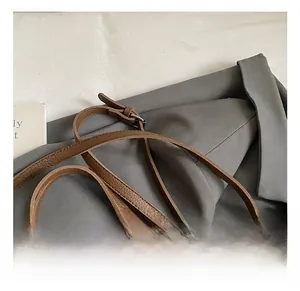 Close-up of adjustable dark brown pebble leather shoulder strap with silver buckle