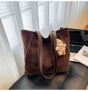 Détail d'un sac cabas en suédine marron foncé avec motifs gaufrés et fermetures éclair