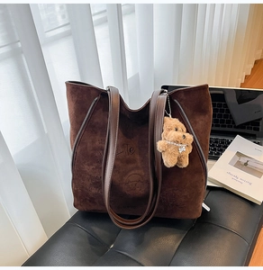 Détail du cabas en faux daim marron foncé avec motif chat en relief et breloque en peluche