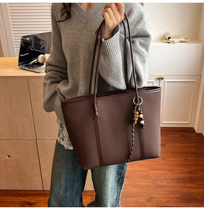 Close-up of a deep brown matte PU leather tote bag with colorful beaded charm details