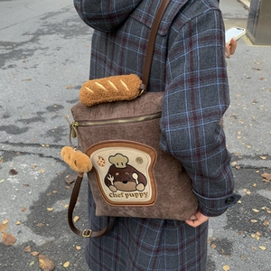 Detail of corduroy backpack with Chef Puppy embroidery and baguette plush handle