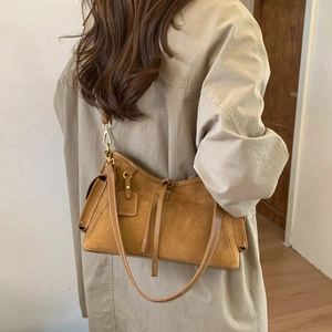 Detail of vintage brown suede shoulder bag with detachable strap and elegant side fringe